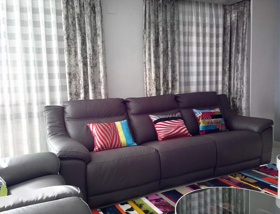 Sofá de piel gris con cojines - Villalba Interiorismo