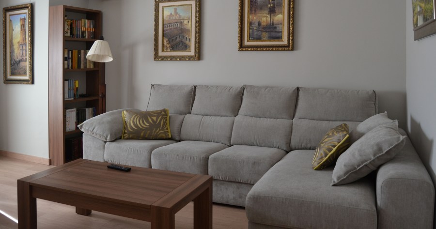 Sofá gris cojines amarillos - Villalba Interiorismo