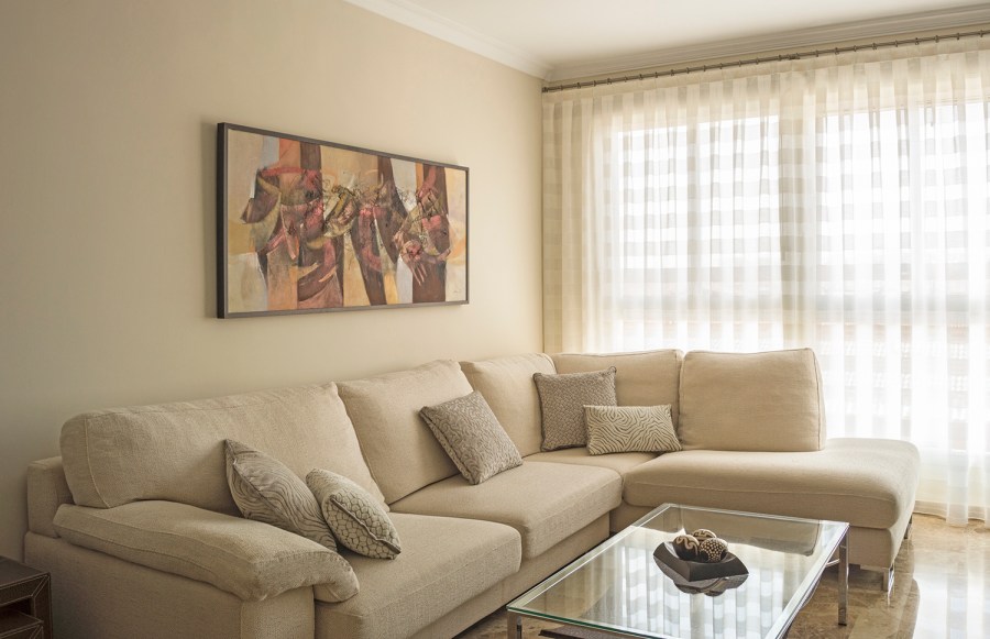 Salón con cortina y sofá en tonos naturales - Villalba Interiorismo