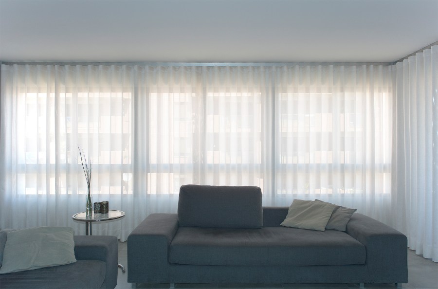 Salón moderno blanco y gris con cortinas en onda perfecta - Villalba Interiorismo